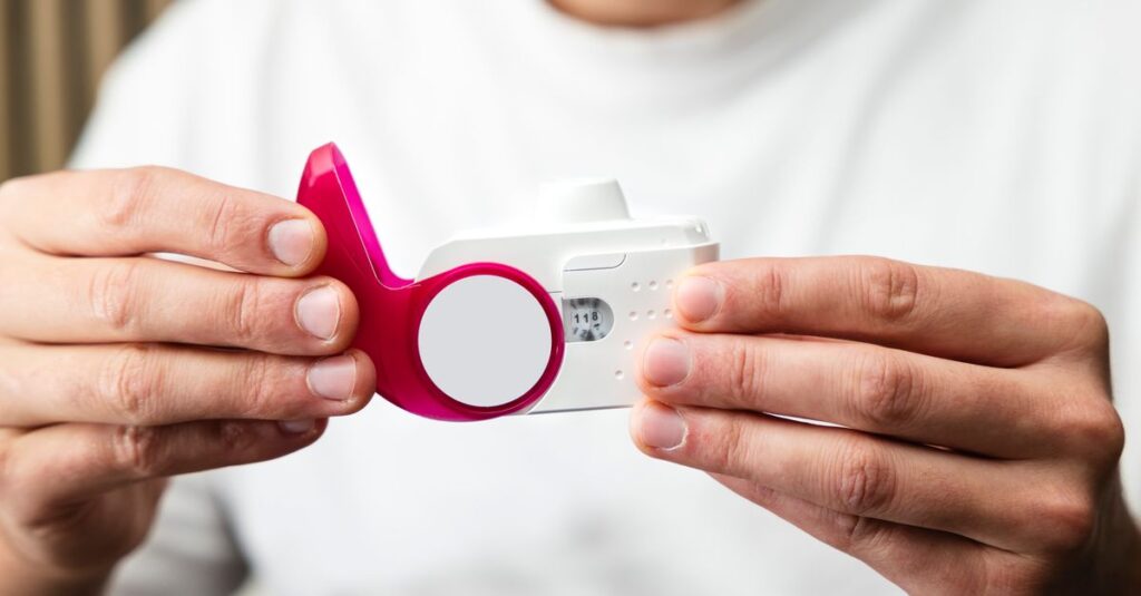 Close-up of hands holding a peak flow meter for respiratory health monitoring.